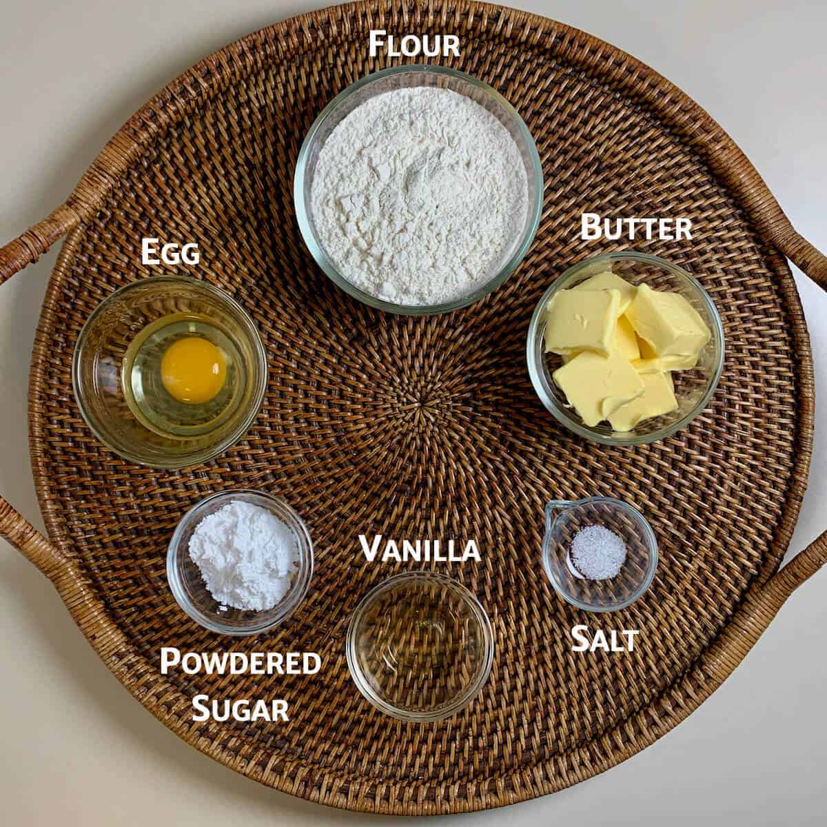 Shortcrust pastry ingredients on a wooden tray from overhead.