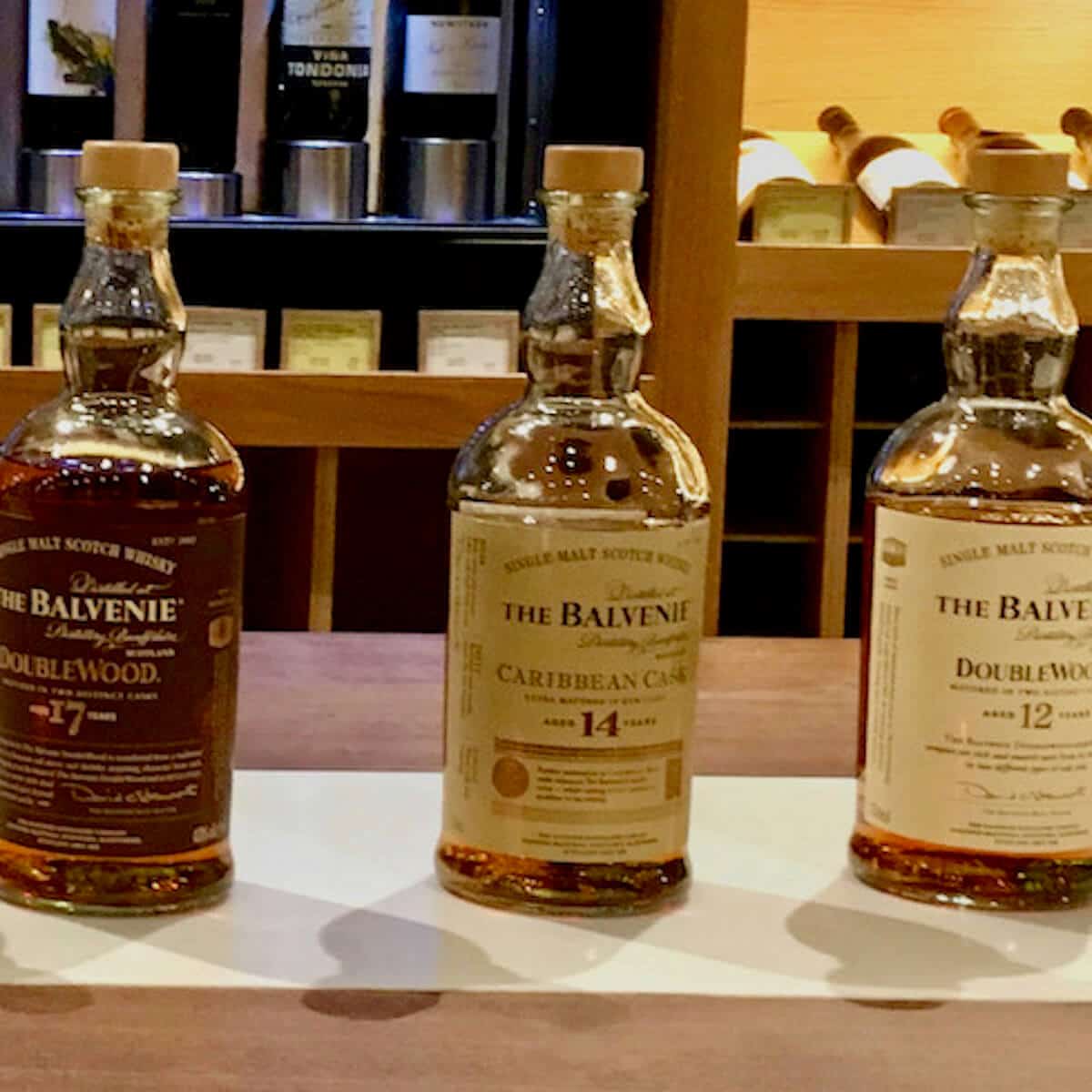 The Balvenie 12 year, 14 year, and 17 year lineup bottles on a counter.