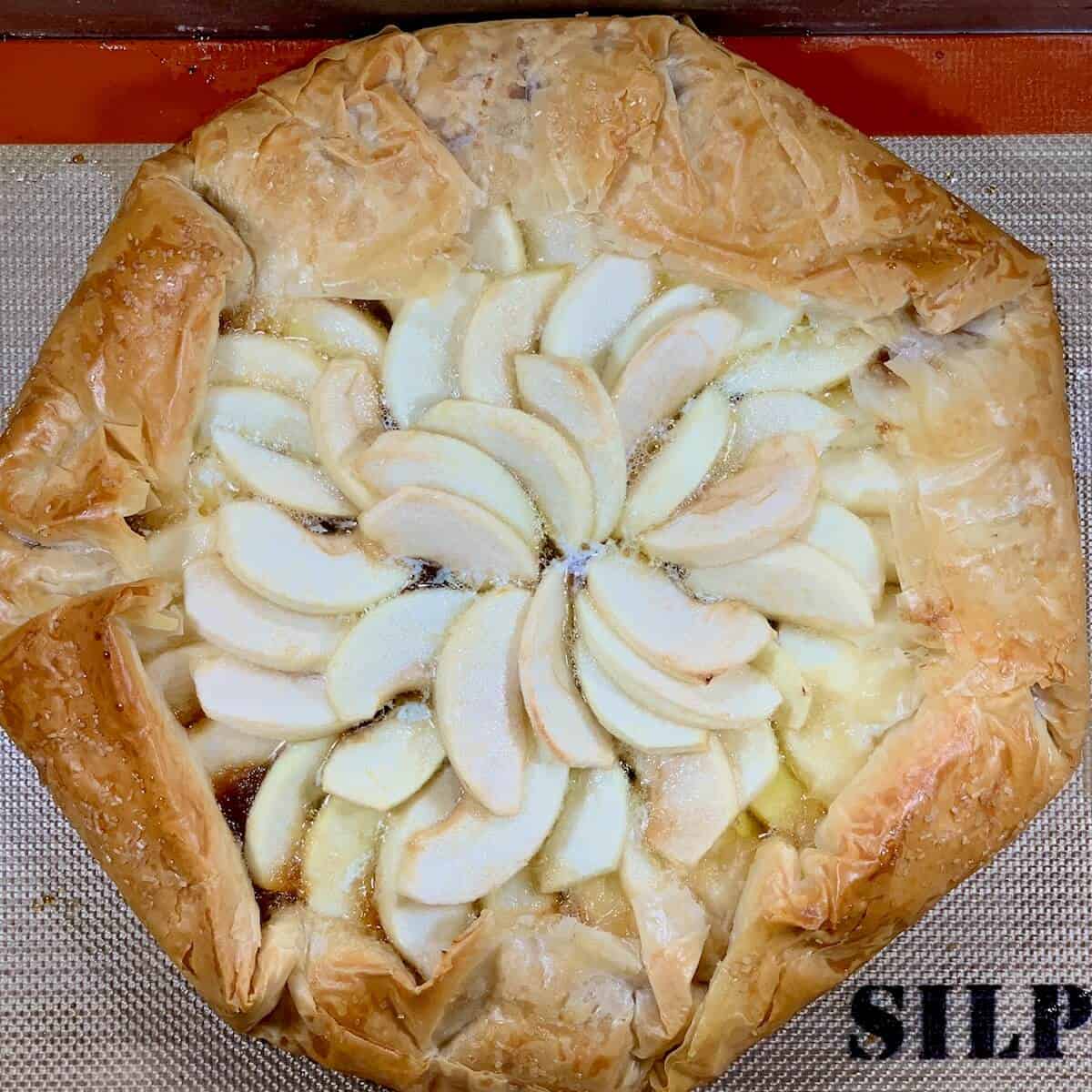 Baked apple galette on a baking pan from overhead.