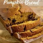Sliced Pumpkin Bread on a wood tray on a brown scarf Pinterest banner..