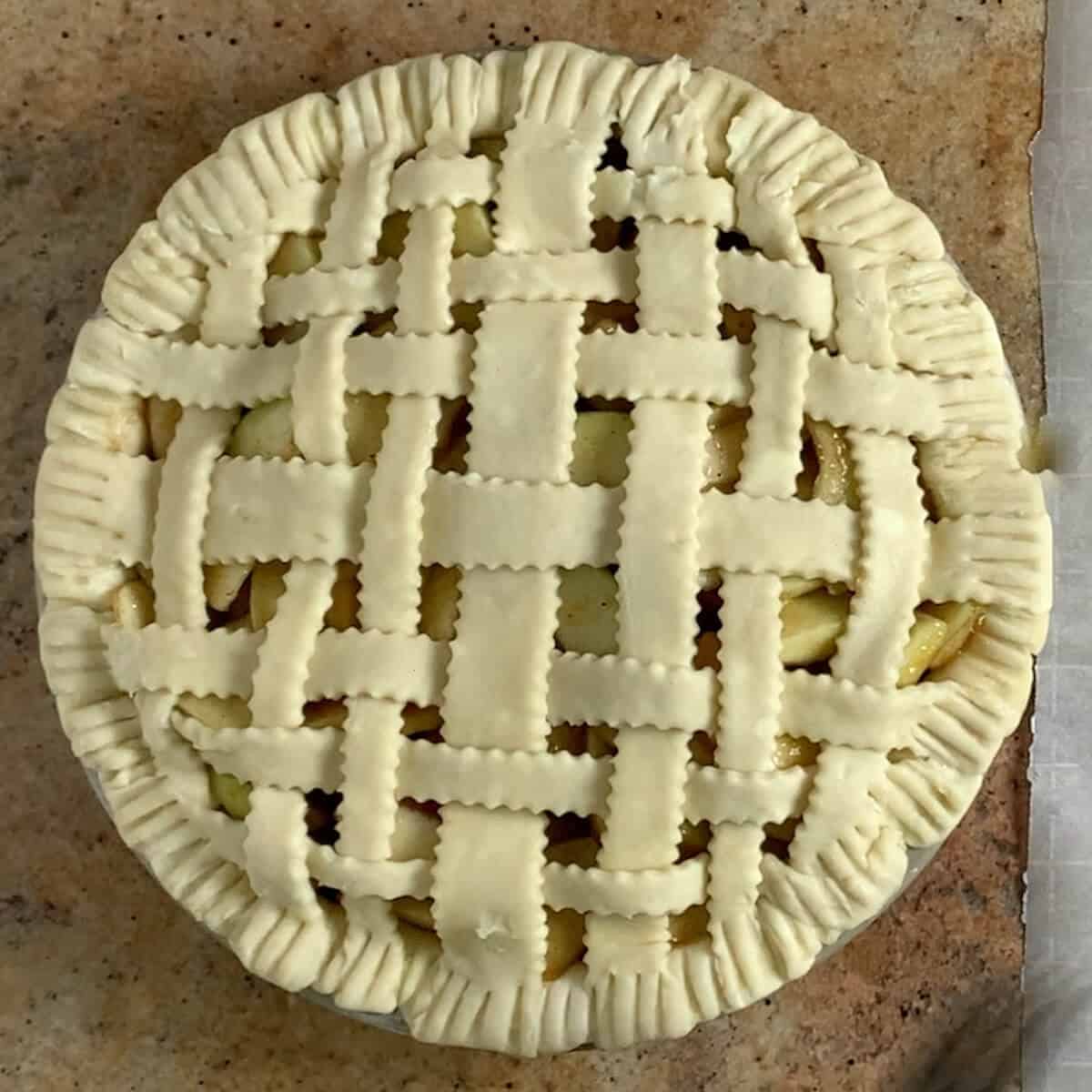 Unbaked lattice top apple pie.