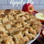 Lattice topped apple pie on a purple striped towel with cut apples Pinterest banner.