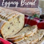 Sliced eggnog bread on a plaid towel in a basket with mug of eggnog behind Pinterest banner.