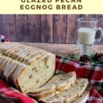 Sliced eggnog bread on a plaid towel in a basket with mug of eggnog behind Pinterest banner.