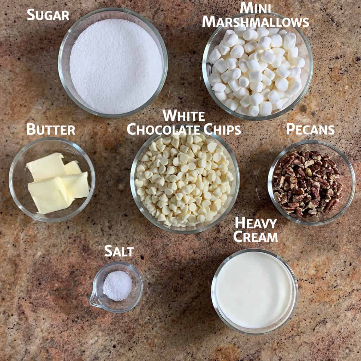 Ingredients for white chocolate pecan fudge portioned into glass bowls.