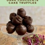 Chocolate cake truffles stacked on a glass plate stand with pink flowers below Pinterest banner.