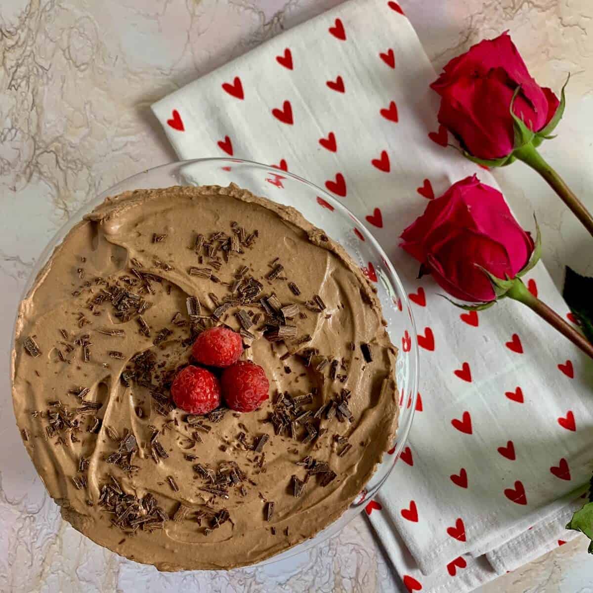 Chocolate Mousse Cake next to a heart-spotted towel and roses from overhead.