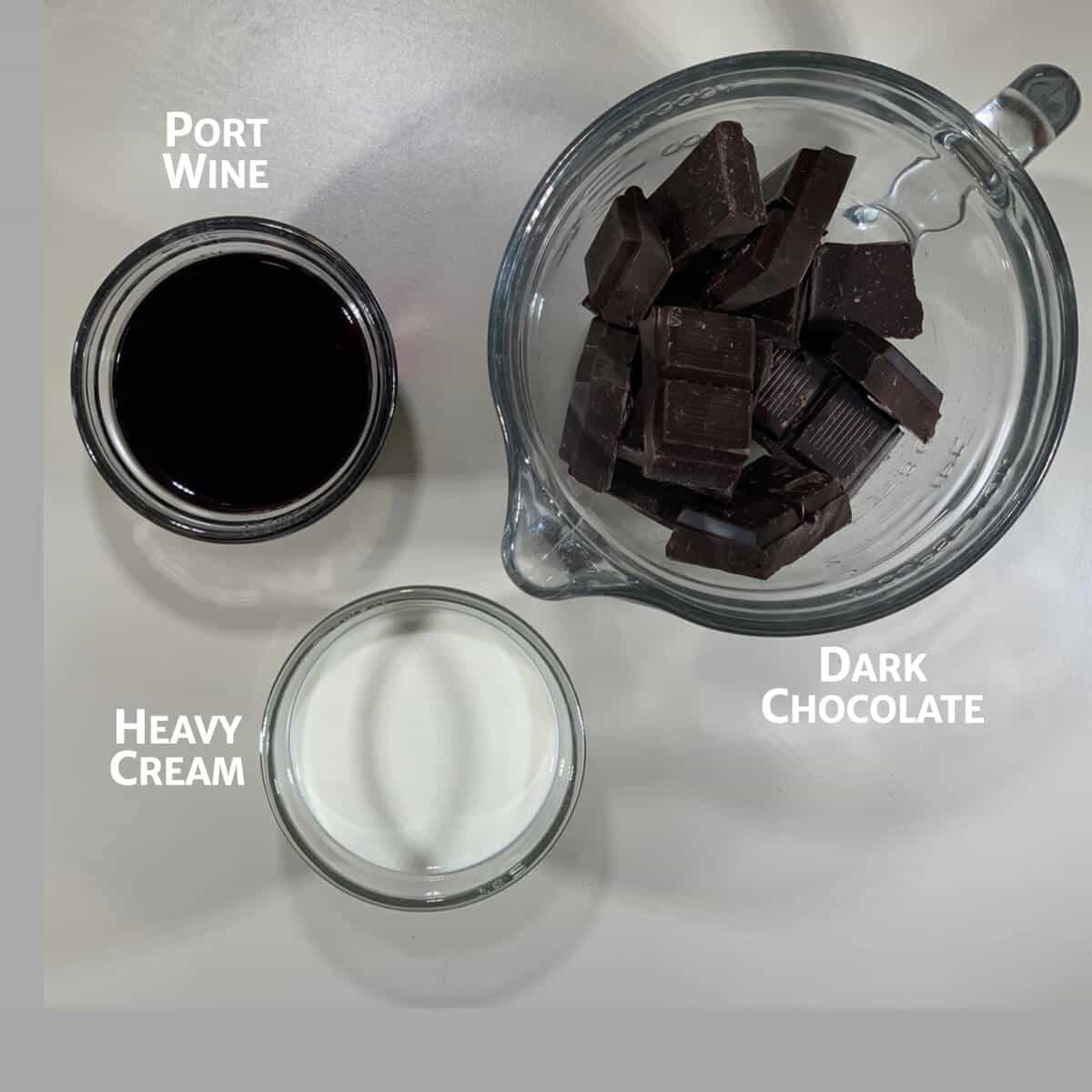 Ingredients for port wine chocolate ganache in glass bowls from overhead.