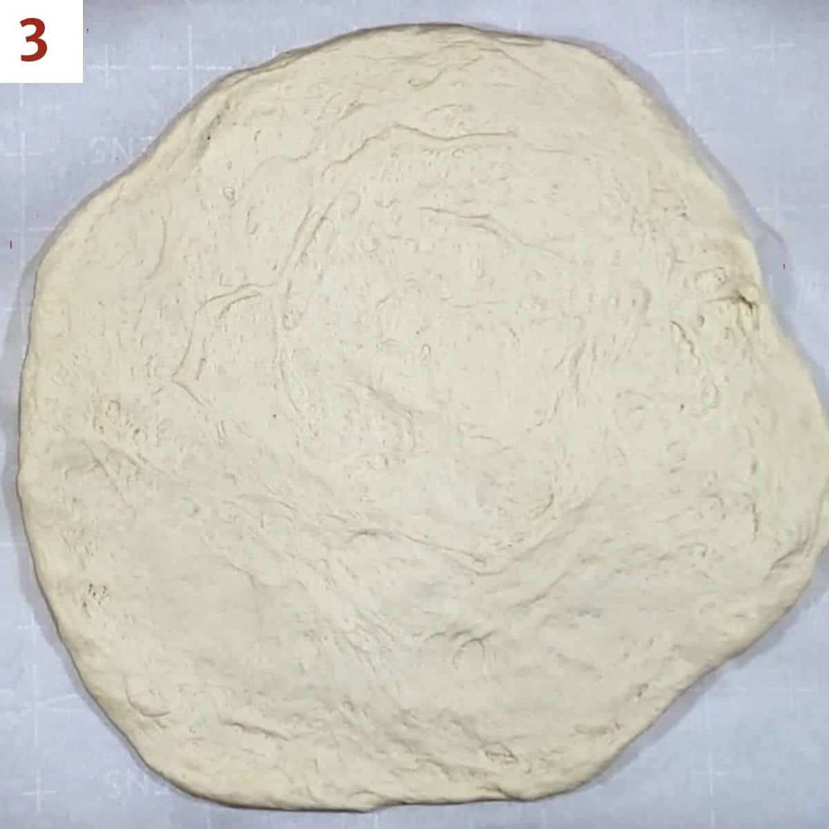 Pizza dough pressed out before topping.