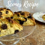 Chocolate chip scones on a cake stand with one on a flowered plate behind Pinterest banner.