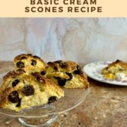 Chocolate chip scones on a cake stand with one on a flowered plate behind Pinterest banner.