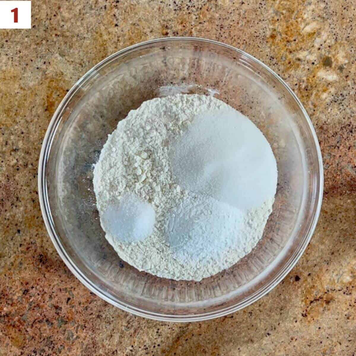 Flour, sugar, baking powder, & salt in a glass bowl.