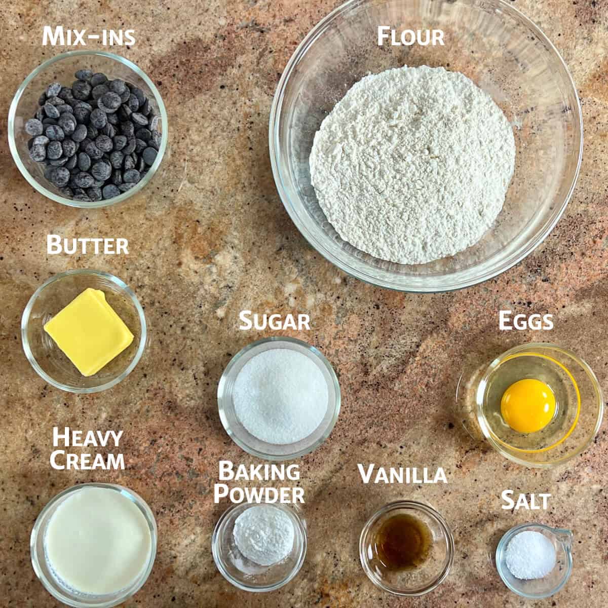 Ingredients for basic scones portioned in glass bowls from overhead.