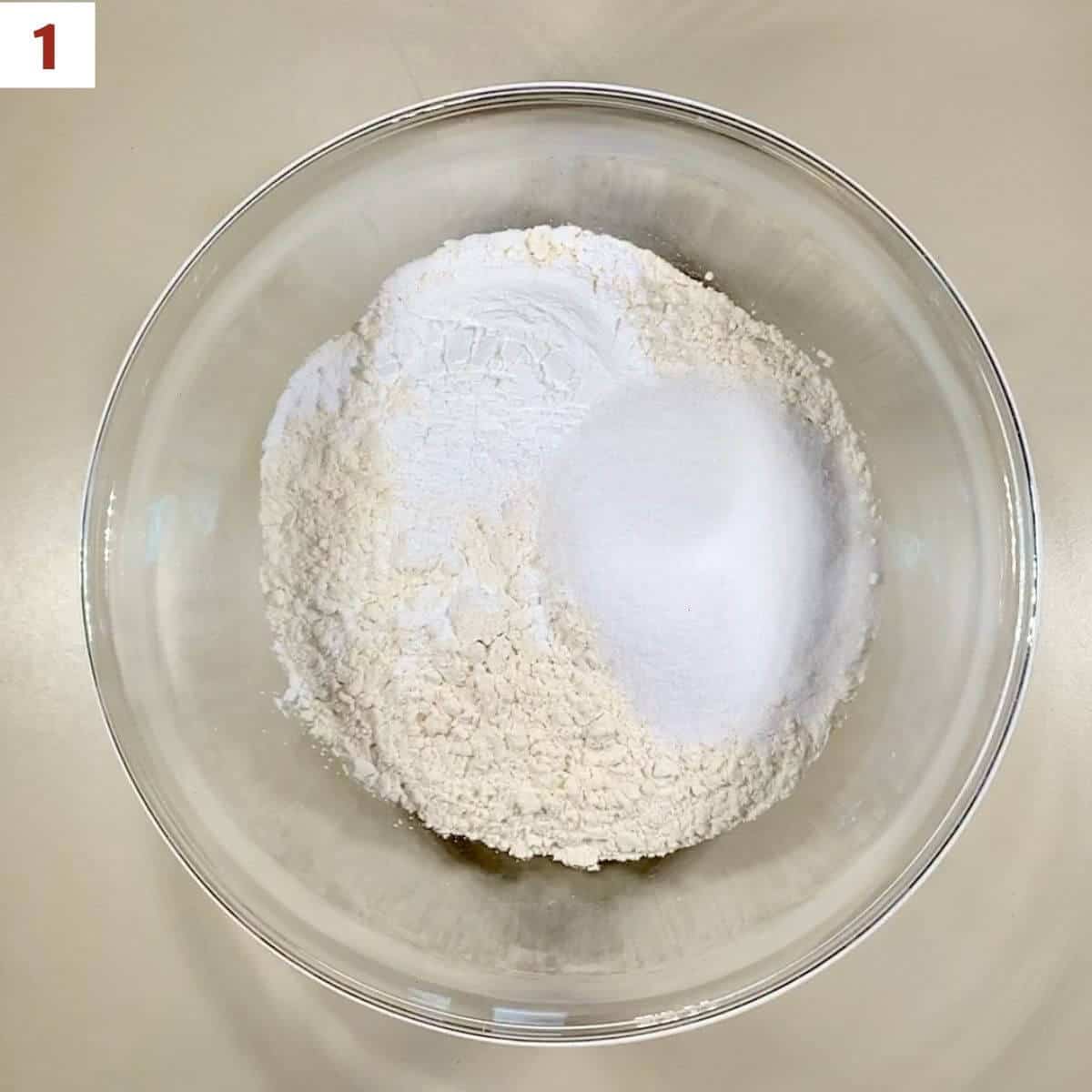 Flour, sugar, baking power, & salt in a glass bowl.