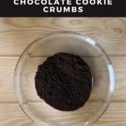 Chocolate cookie crumbs in a glass bowl from overhead Pinterest banner.