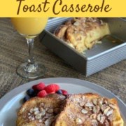 French Toast with berries on a grey plate with orange juice & pan behind Pinterest banner.