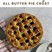 Lattice blueberry pie on a red & white striped towel next to a pie server & white plates with forks from overhead Pinterest banner.