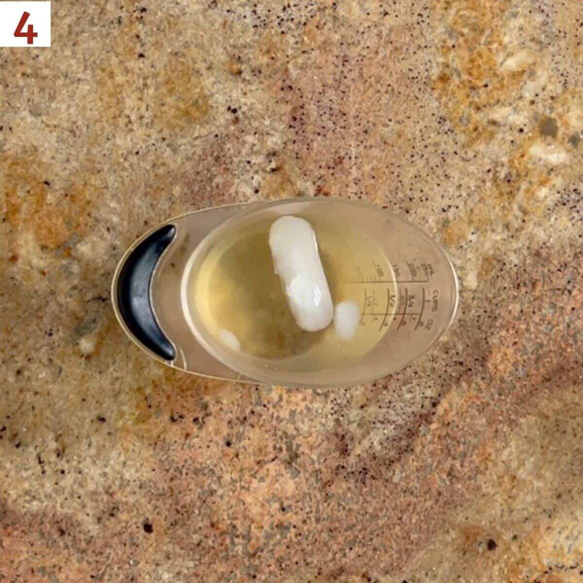 Ice water and apple cider vinegar in a measuring cup.