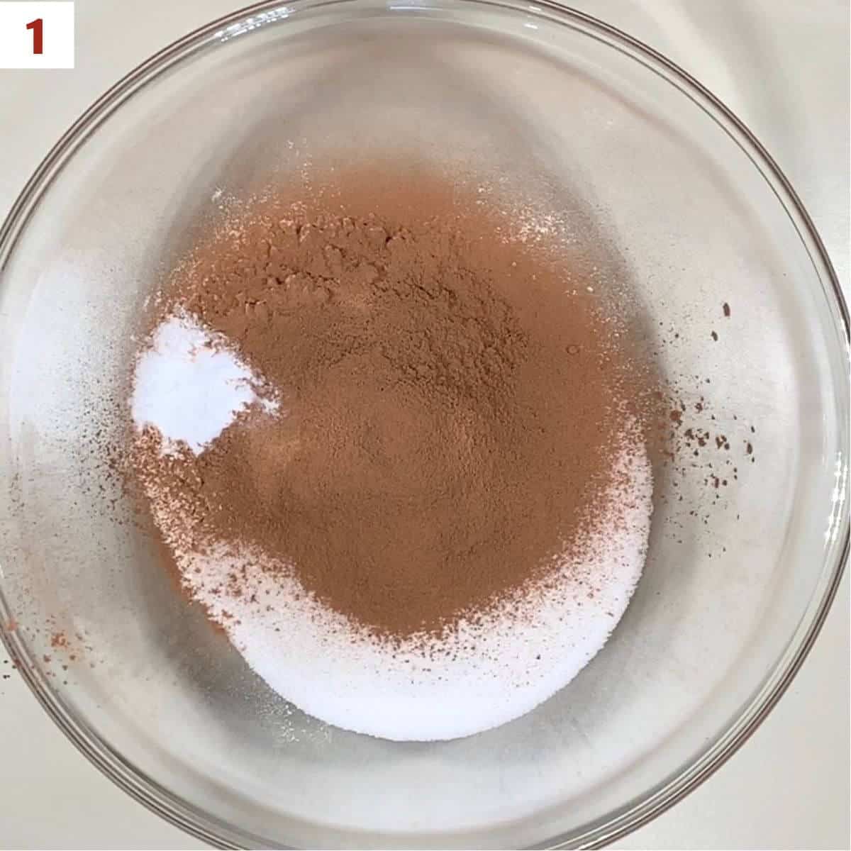 Flour, sugar, cocoa powder, baking soda, and salt in a glass bowl from overhead.