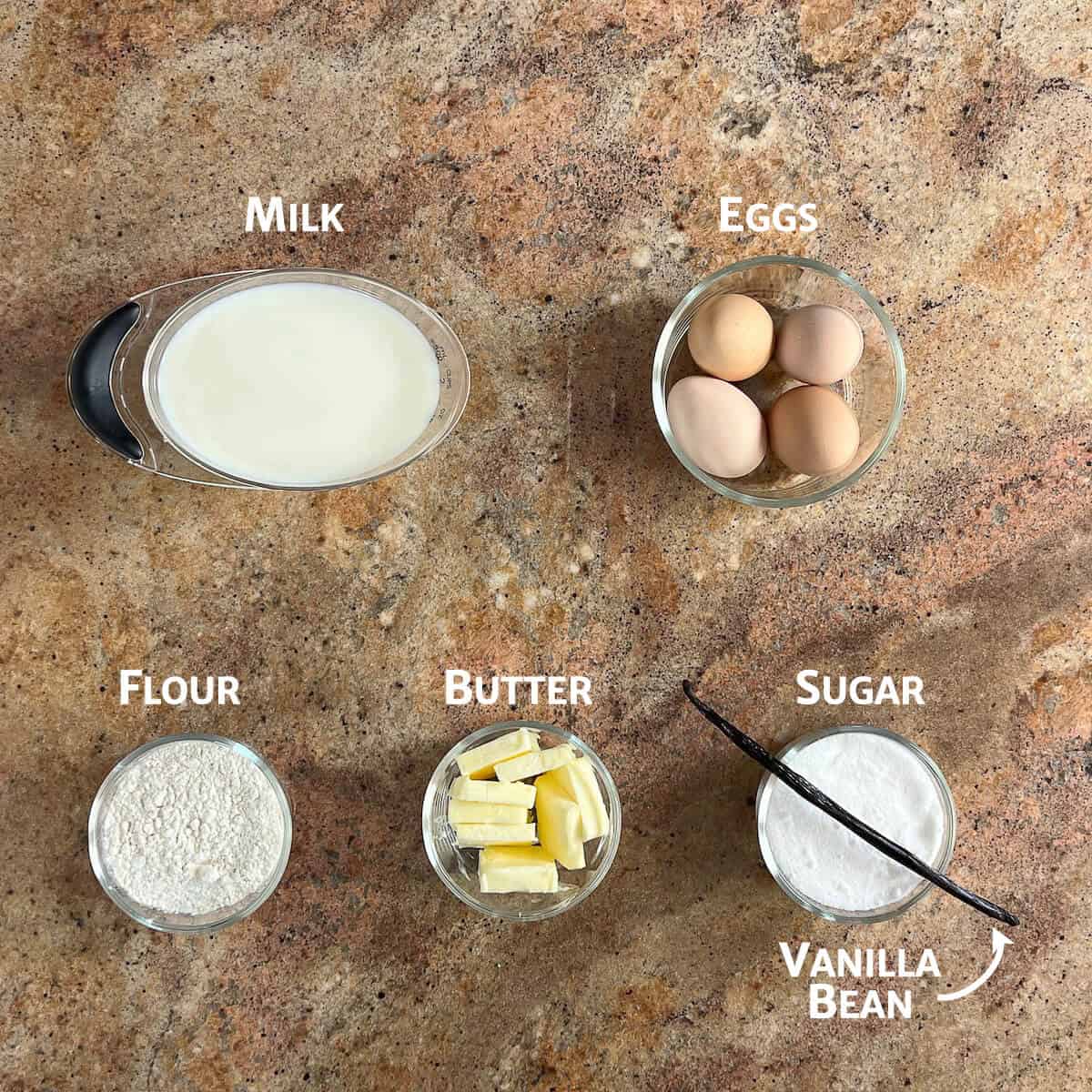 Ingredients for Magic Custard Cake portioned into glass bowls from overhead.