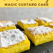 Magic Custard Cake slices on a black slate platter Pinterest banner.