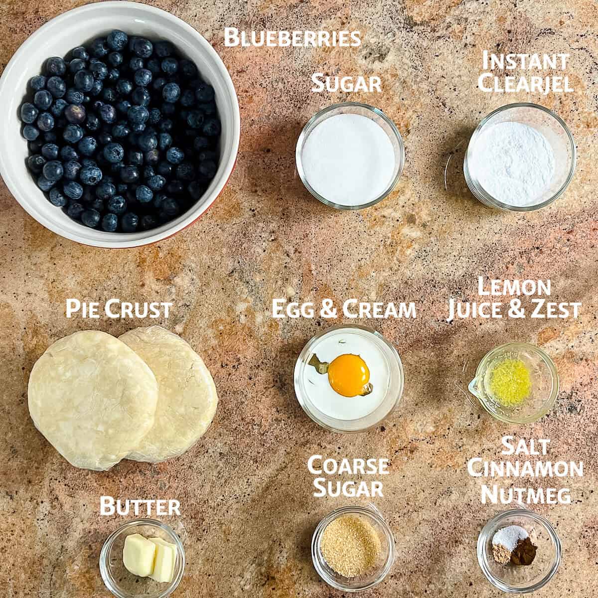 Blueberry pie ingredients portioned into glass bowls from overhead.