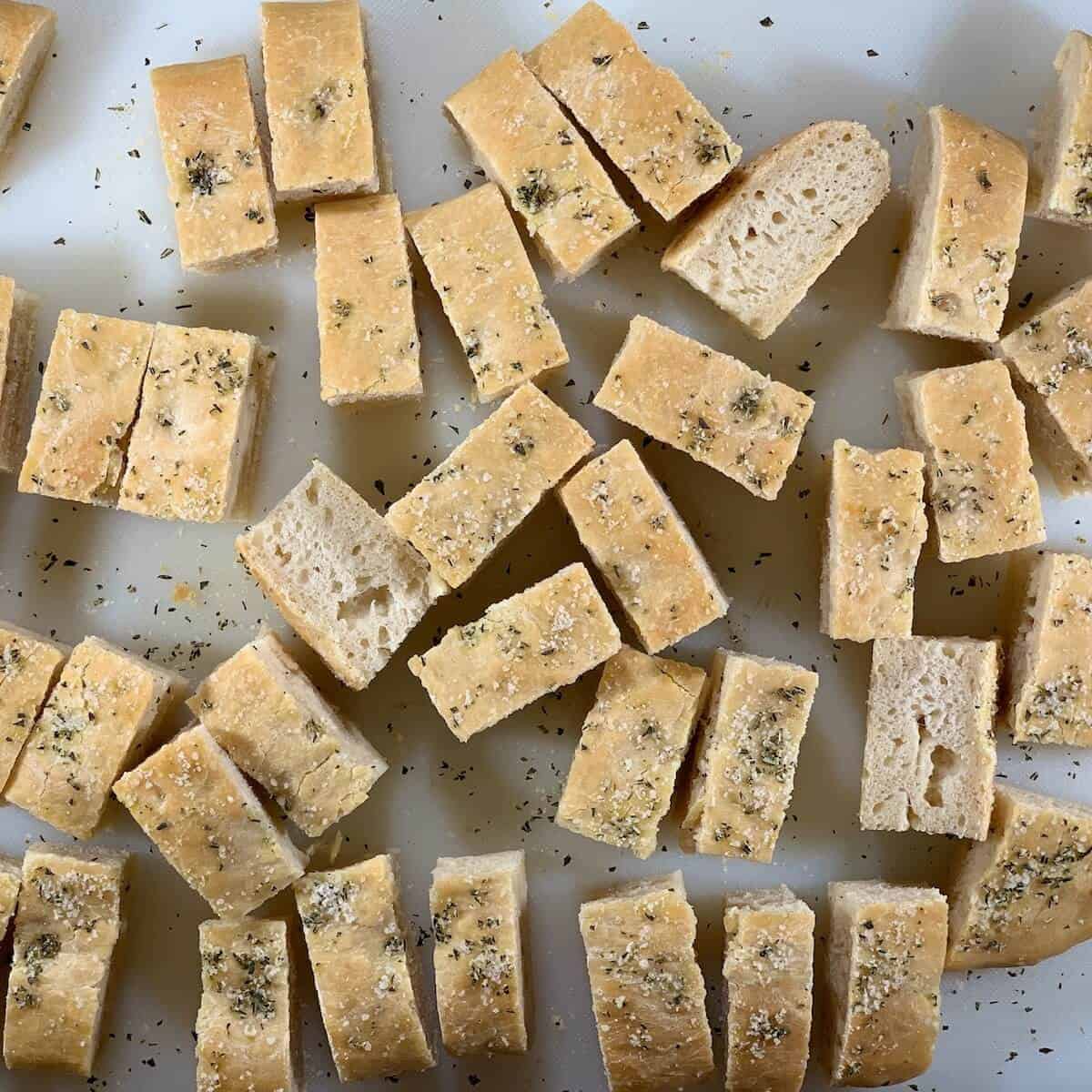 Pieces of sourdough focaccia on a cutting board.