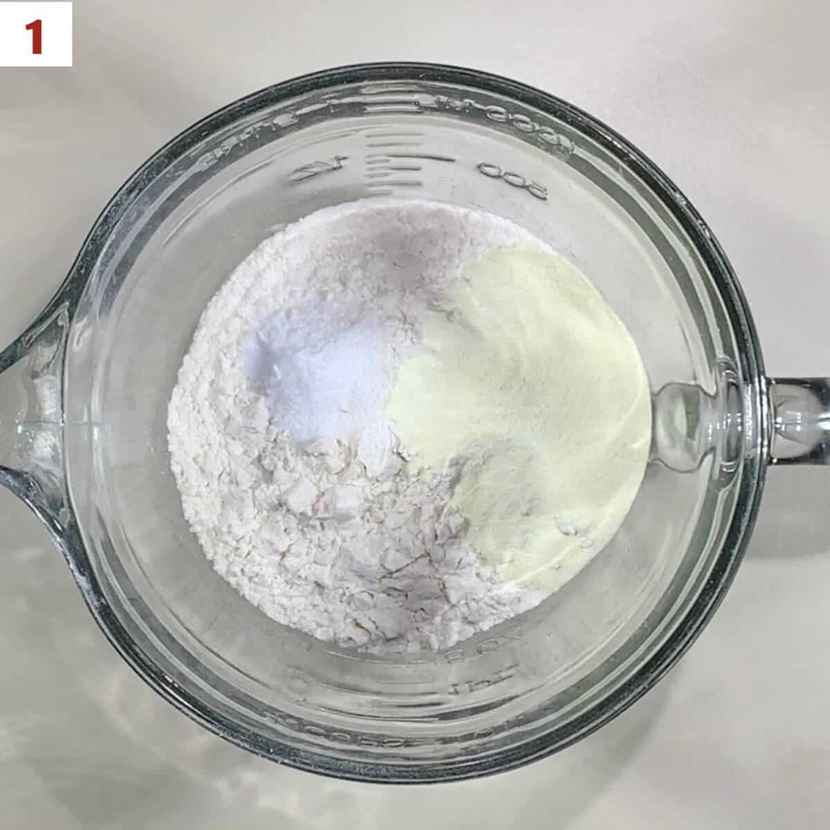 Mixing flour, baking soda, buttermilk powders, and salt in a glass bowl.