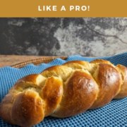 Whole challah loaf on a blue towel Pinterest banner.