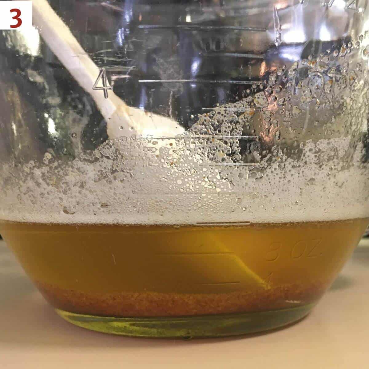 Side on view of brown butter in a glass mixing bowl.