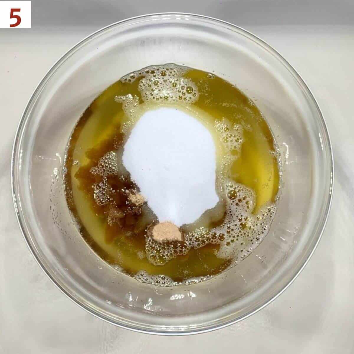 Brown butter, brown sugar, and granulated sugar in a glass mixing bowl.