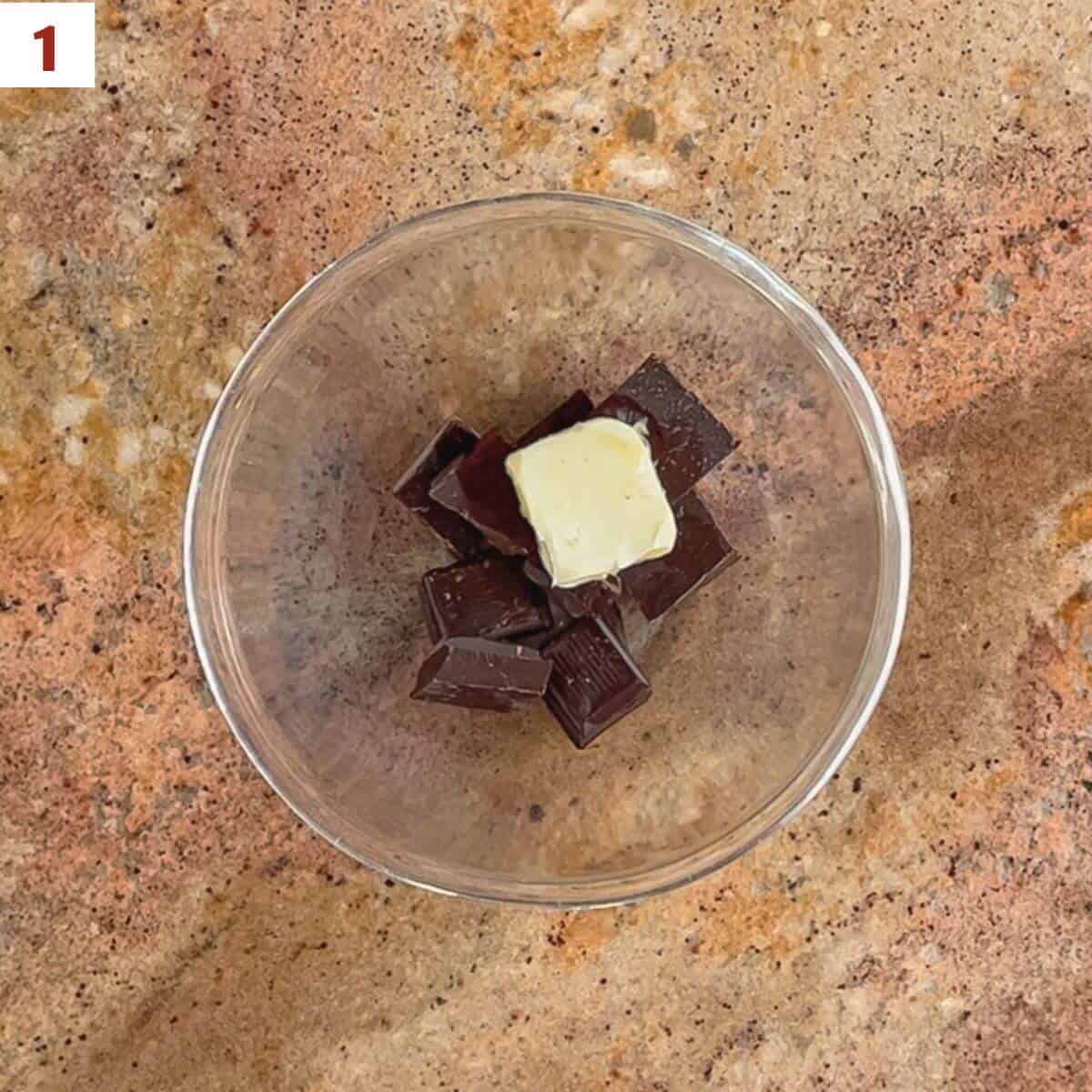 Dark chocolate, butter, and vanilla in a glass bowl.