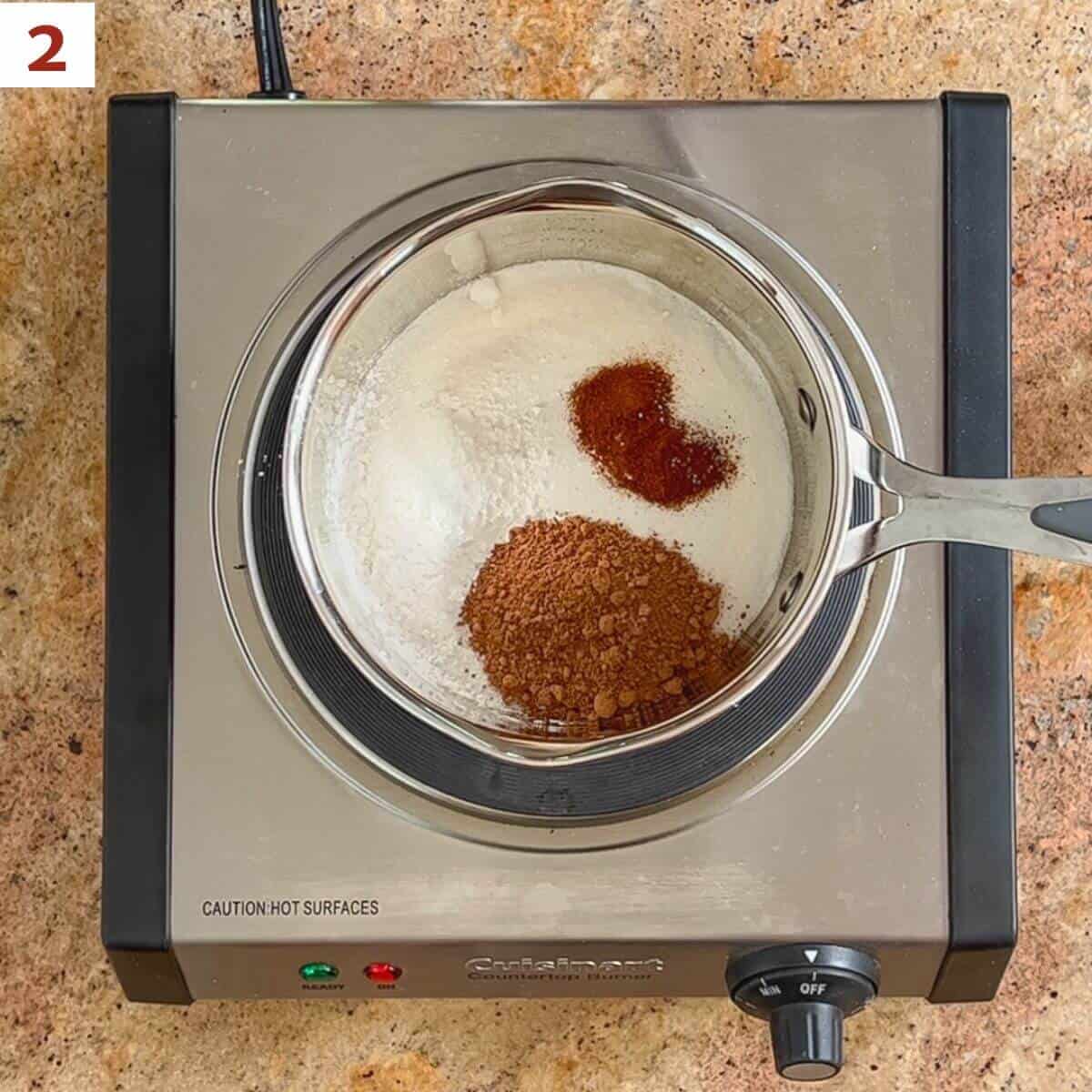 Sugar, cornstarch, cocoa powder espresso powder, and salt in a small saucepan sitting on a hot plate.