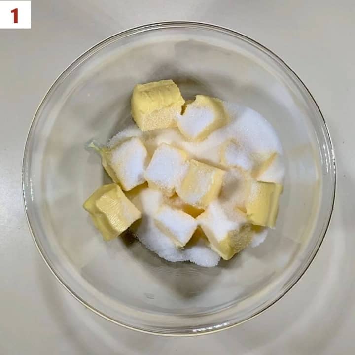 Combining butter and sugar in a glass bowl.