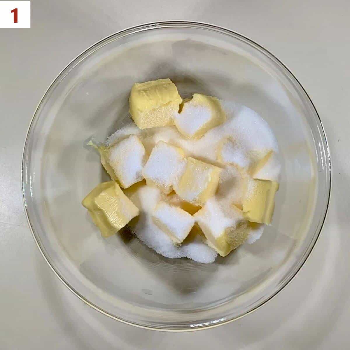 Combining butter and sugar in a glass bowl.