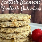 Bannocks stacked on a white plate with raspberries Pinterest banner..