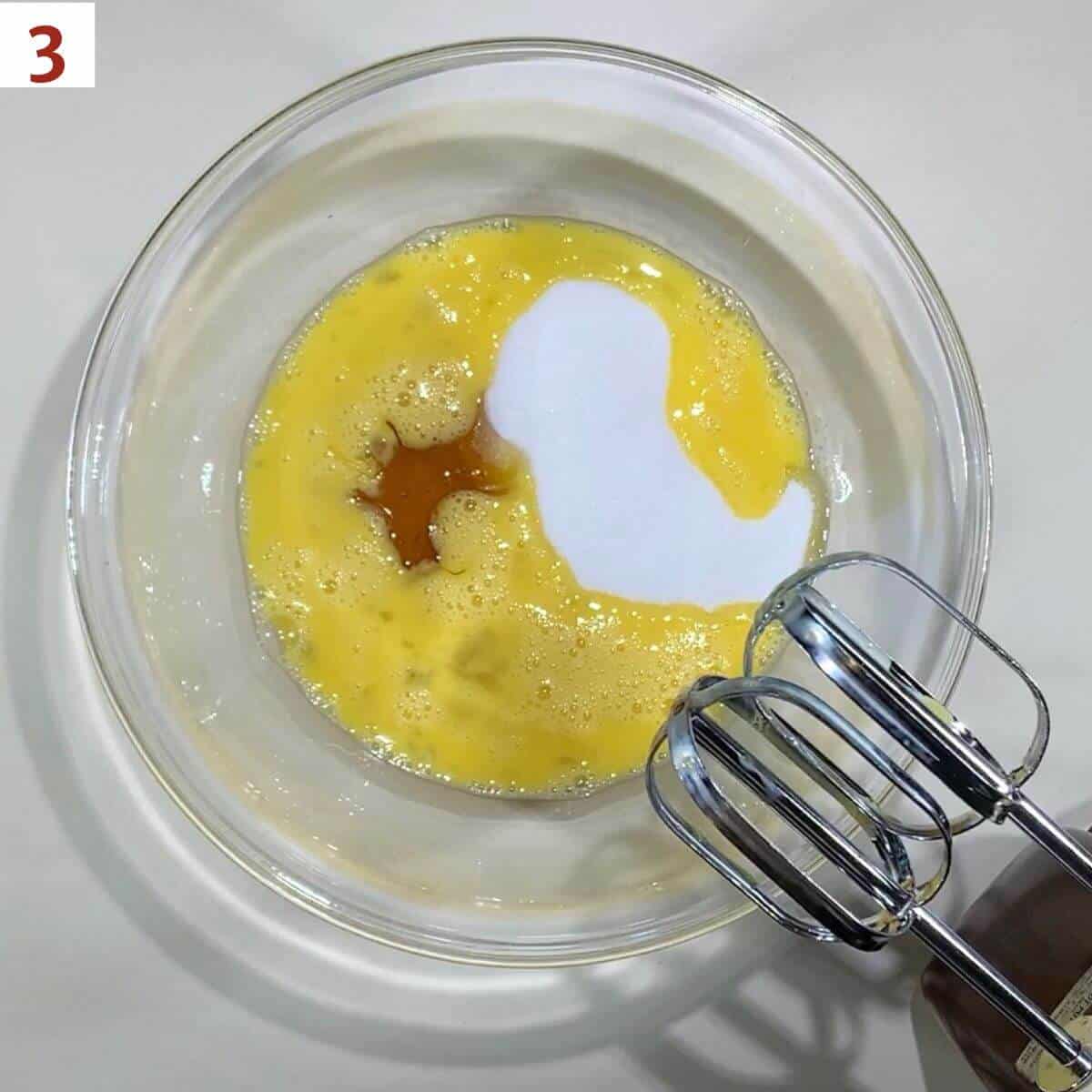 Eggs, sugar, and honey in a glass bowl.