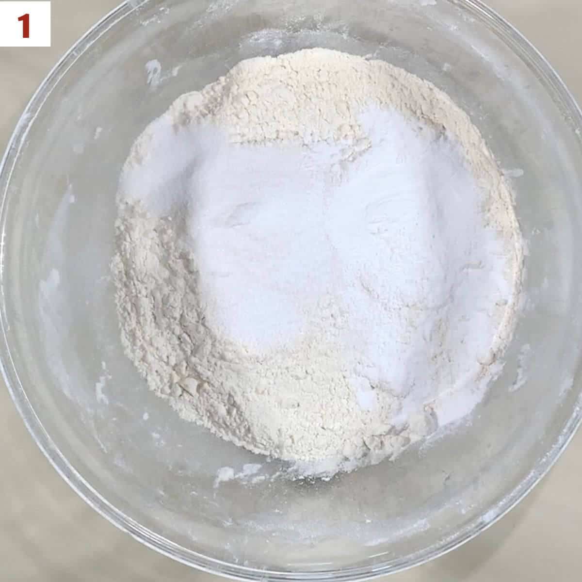 Flour, sugar, baking power, & salt in a glass bowl.