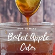 Boiled apple cider dripping from a spoon into a glass jar Pinterest banner.