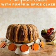 Whole sourdough pumpkin cake on a white cake stand next to a wicker cornucopia filled with gourds & small pumpkins Pinterest banner.