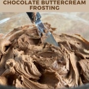 Bowl of dark chocolate buttercream frosting with an offset spatula sticking out Pinterest banner.