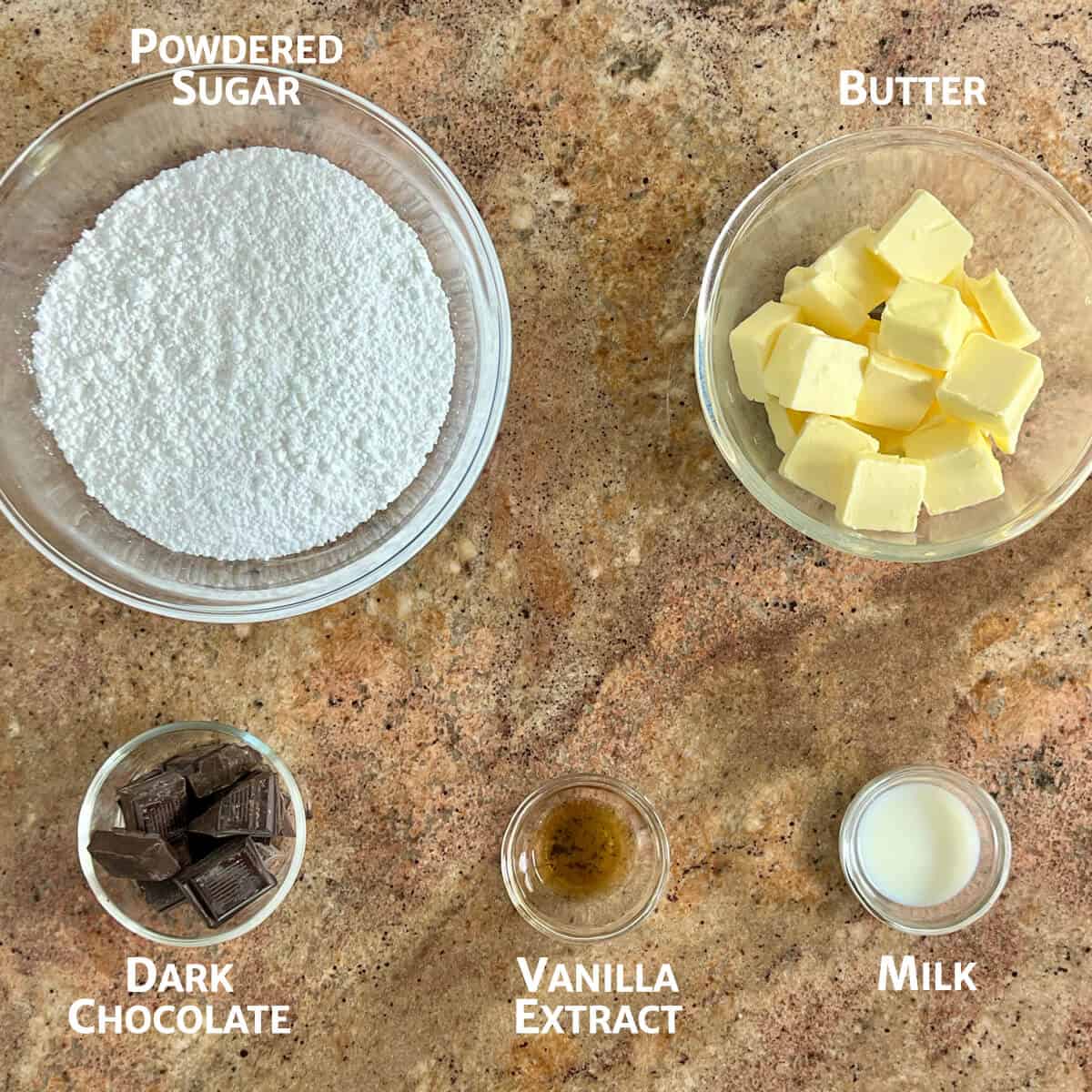Ingredients for dark chocolate buttercream frosting portioned into glass bowls.