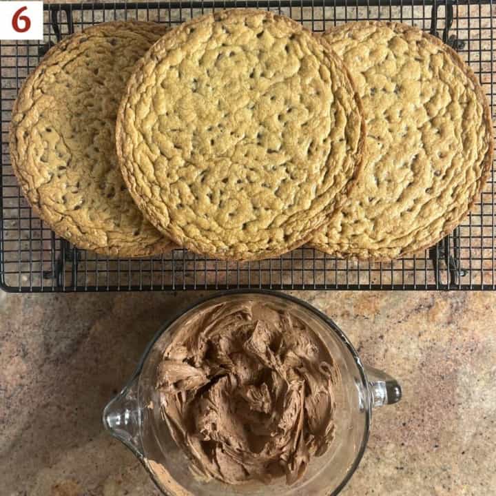 Cake layers on a cooling rack next to a bowl of chocolate frosting from overhead.