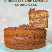 Whole Chocolate Chip Cookie Cake on a blue cake stand with a slice lifted Pinterest banner.