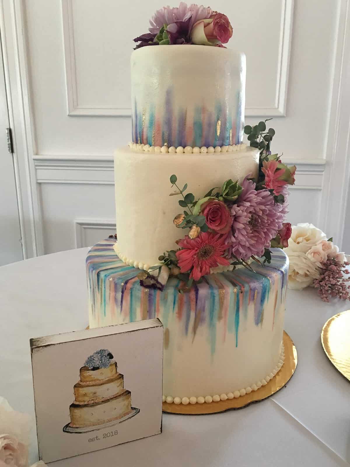 Finished wedding cake at the venue next to a small wedding cake sign.