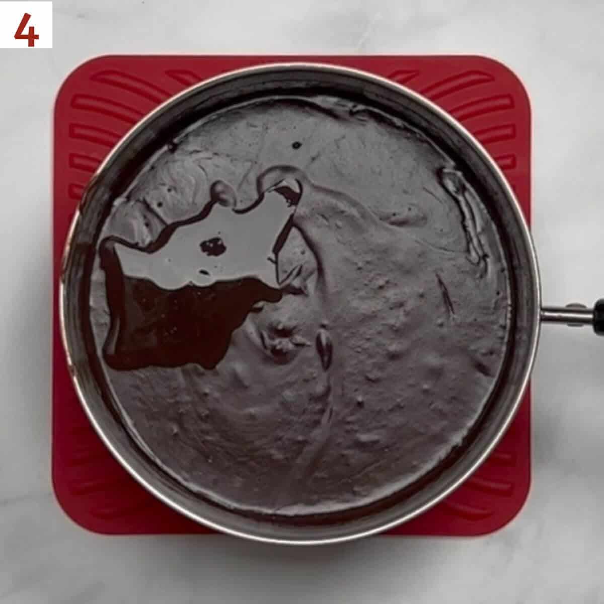 Adding vanilla extract to cooked pudding.
