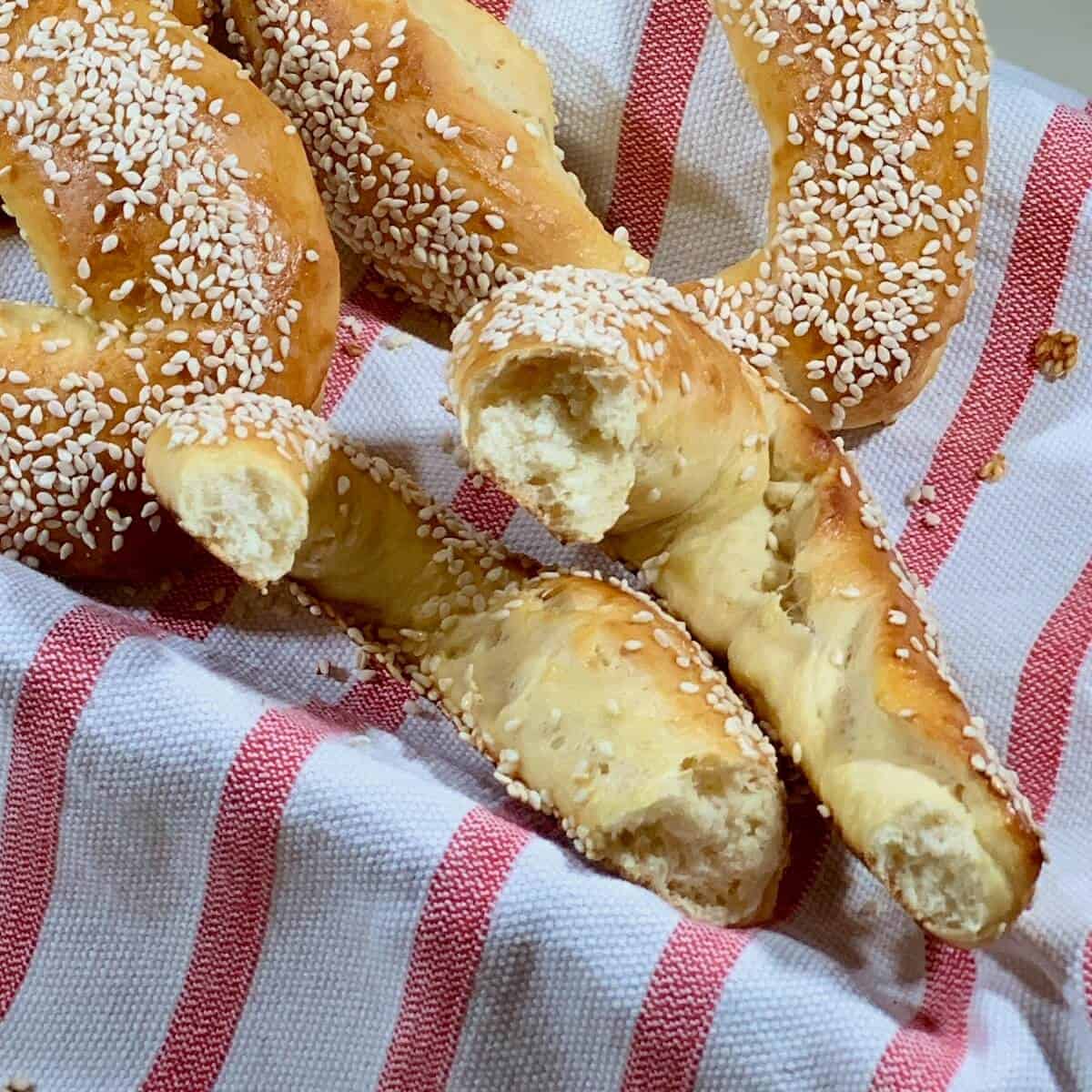 Sourdough Jerusalem Bagels broken in half in a basket lined with a red & white striped towel.