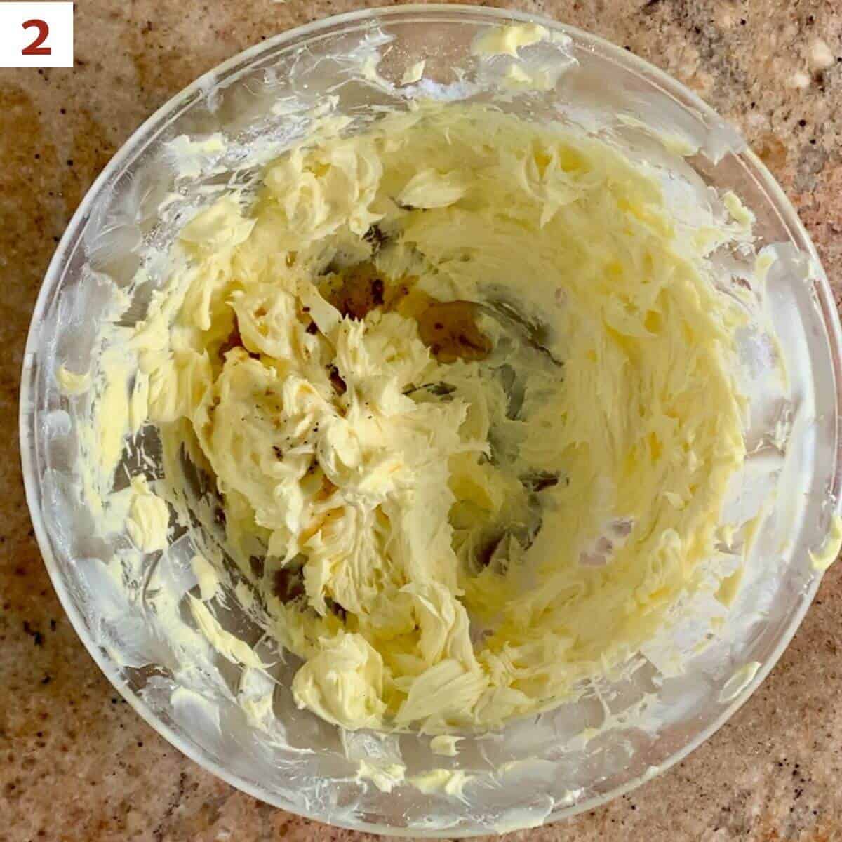 Adding vanilla to butter & sugar mixture in a glass bowl.