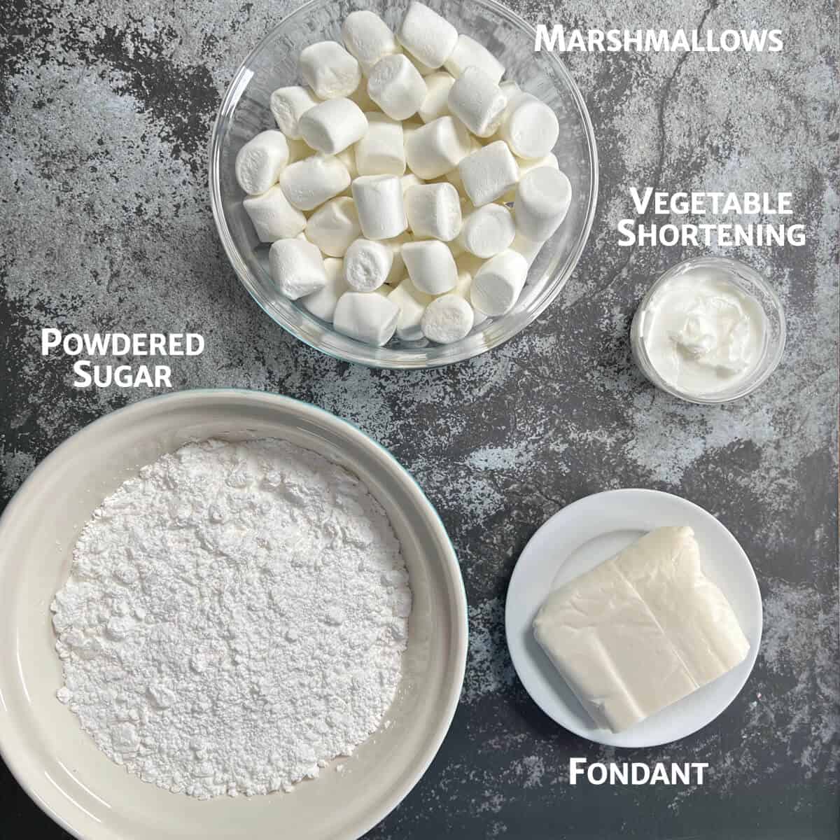 Ingredients for marshmallow fondant portioned into bowls from overhead.