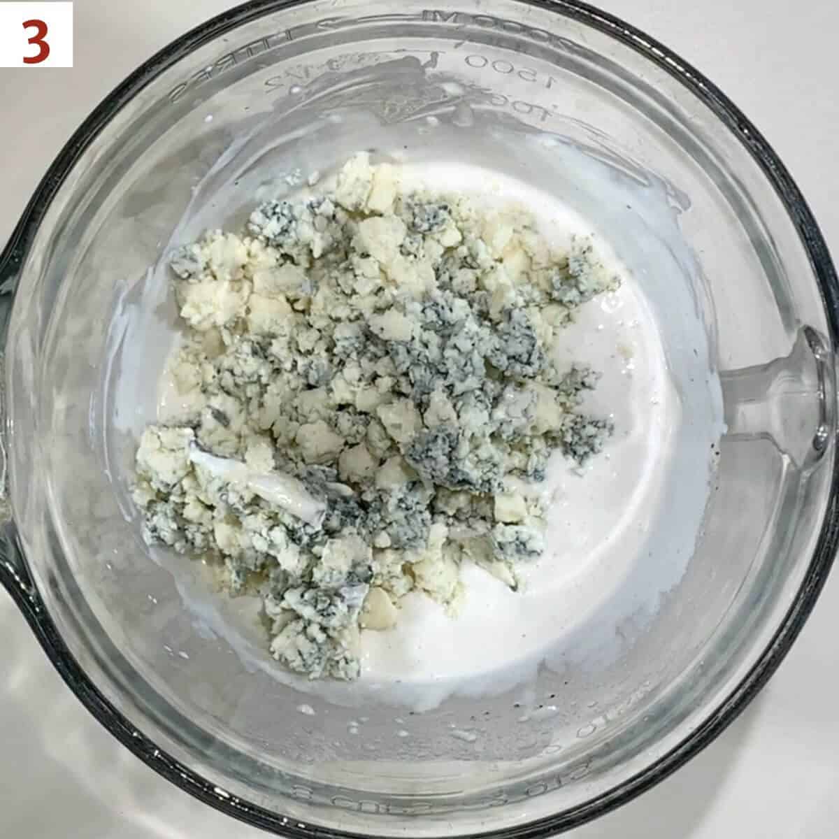 Adding crumbled blue cheese to the dressing base.